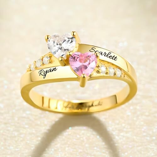 Bague en or avec pierres en forme de cœur et noms gravés.